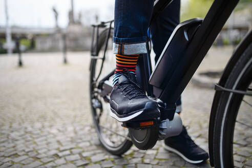 Geschäftsmann auf dem Weg zur Arbeit, Nahaufnahme seiner Beine beim Fahrradfahren. - HPIF01818