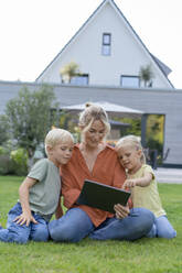 Happy mother sharing tablet PC with children in garden - JOSEF15043