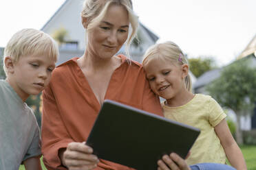 Lächelnde Frau zeigt Kindern einen Tablet-PC - JOSEF15045