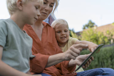 Woman using tablet PC sitting with children - JOSEF15047