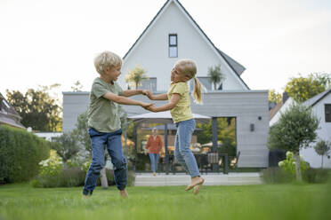 Glückliches Mädchen und Junge spielen im Garten - JOSEF15066