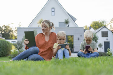 Family with wireless technologies in back yard - JOSEF15067