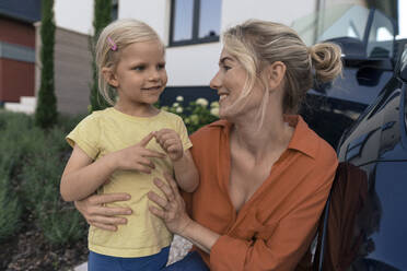 Glückliche Mutter schaut auf lächelnde Tochter im Vorgarten - JOSEF15104