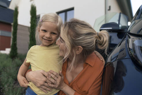 Glückliche Mutter, die ihre Tochter im Auto umarmt - JOSEF15105