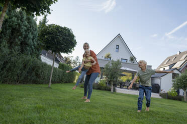 Verspielte Frau mit Kindern im Garten - JOSEF15114