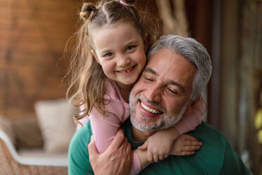 A portrait of little cute daughter hugging her happy father at home. - HPIF02062