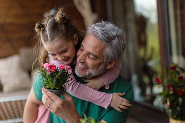 Ein Porträt der kleinen süßen Tochter, die ihren glücklichen Vater zu Hause umarmt. - HPIF02063