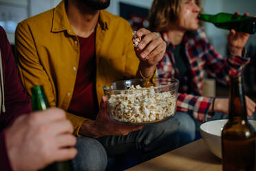 Close-up of football fans friends watching match and eating popcorn. - HPIF02132