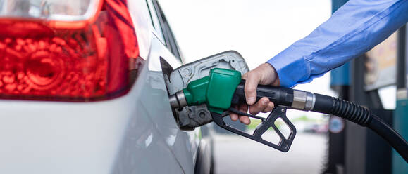 Eine Hand, die das Auto an der Tankstelle mit Kraftstoff betankt - HPIF02183