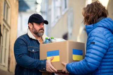 Freiwillige Helfer sammeln Kartons mit humanitärer Hilfe für die ukrainischen Einwanderer auf der Straße. - HPIF02246