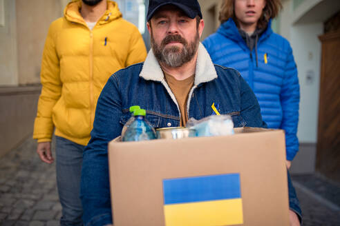 Das Team von Freiwilligen sammelt Kartons mit humanitärer Hilfe für ukrainische Flüchtlinge auf der Straße - HPIF02250