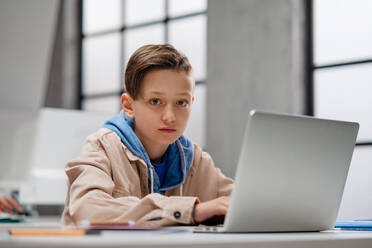 A schoolboy using computer in classroom at school - HPIF02321