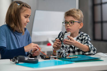 Schüler in der Schule arbeiten mit elektronischen Bauteilen in einem Robotik-Klassenzimmer. - HPIF02325