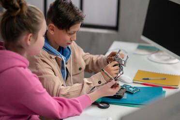 Schüler in der Schule arbeiten mit elektronischen Bauteilen in einem Robotik-Klassenzimmer. - HPIF02329