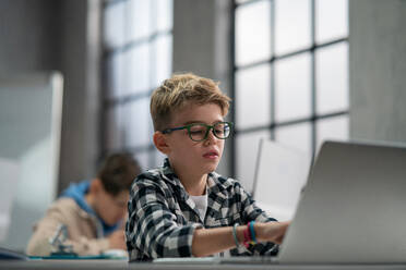 A schoolboy using computer in classroom at school - HPIF02333