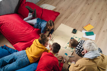 Ein hoher Winkel Ansicht der Gruppe von Kindern mit ihrem Lehrer arbeiten auf IT-Projekt zusammen im Klassenzimmer. - HPIF02364