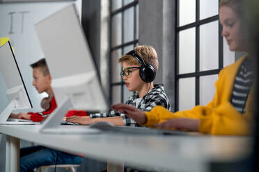 Schulkinder benutzen einen Computer in einem Klassenzimmer in der Schule - HPIF02366