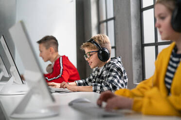 Schulkinder benutzen einen Computer in einem Klassenzimmer in der Schule - HPIF02368