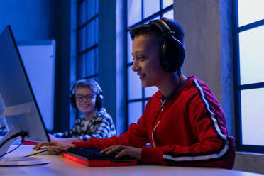 Junge Gamer-Jungs mit Kopfhörern spielen ein Computer-Videospiel. - HPIF02374