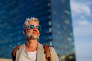 A sccessful happy businesswoman wearing causal clothes and sunglasses in summer in street looking at camera. - HPIF02513