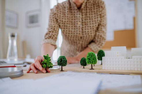 Nahaufnahme einer Architektin mit einem Häusermodell im Büro - HPIF02573