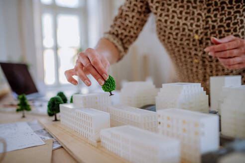 Nahaufnahme einer Architektin mit einem Häusermodell im Büro - HPIF02574