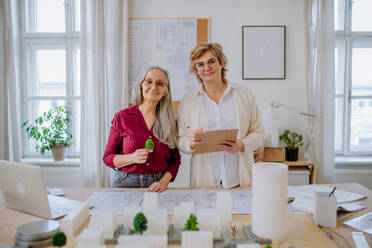 Mature women architects working together in an office, looking at camera. - HPIF02590