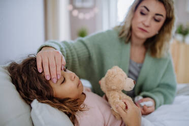 Eine Mutter, die ihre kranke Tochter zu Hause pflegt. - HPIF02911