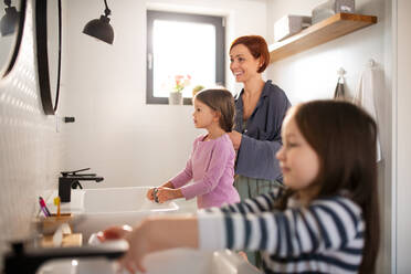 A mother with little children in bathroom, daily routine concept. - HPIF02962