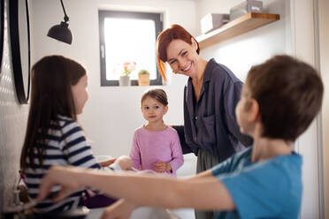 Eine Mutter mit drei kleinen Kindern im Badezimmer, Konzept der Morgenroutine. - HPIF02966