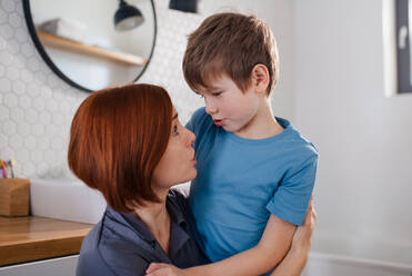 Eine Mutter unterhält sich mit ihrem kleinen Sohn im Badezimmer zu Hause. - HPIF02982