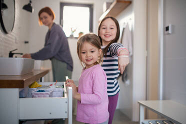 Eine Mutter mit kleinen Kindern im Badezimmer, Konzept der Morgenroutine. - HPIF02989