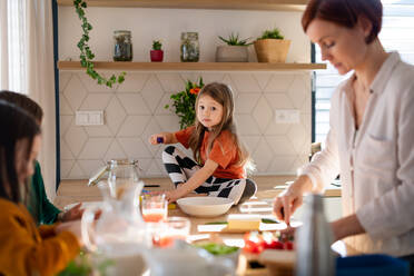 Eine Mutter von drei kleinen Kindern bereitet das Frühstück in der Küche zu Hause vor. - HPIF03013