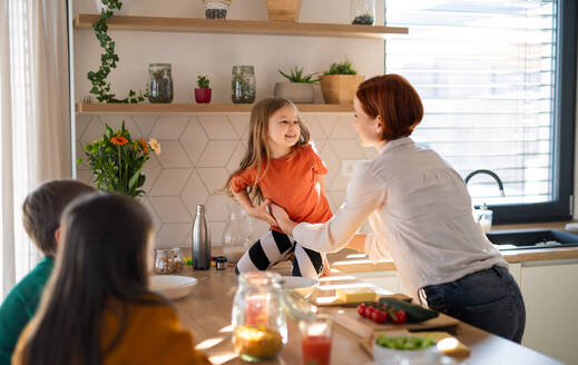Eine Mutter von drei kleinen Kindern bereitet das Frühstück in der Küche zu Hause vor. - HPIF03024