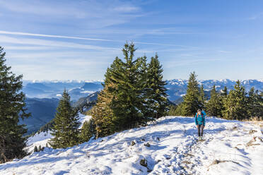 Deutschland, Bayern, Wanderin auf schneebedeckter Bergspitze in den Chiemgauer Alpen - FOF13226