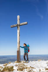 Deutschland, Bayern, Wanderin vor Gipfelkreuz auf der Hochries stehend - FOF13227