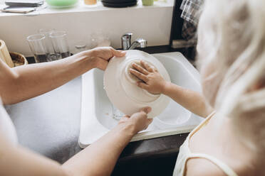 Frau mit Tochter beim Geschirrspülen in der Küche - SIF00581