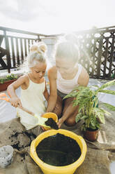 Mutter und Tochter pflanzen gemeinsam auf der Dachterrasse - SIF00606