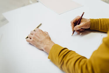 Hands of craftsman drawing in studio - MEUF08804