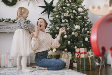 Tochter und Mutter schmücken den Weihnachtsbaum zu Hause - NDEF00255