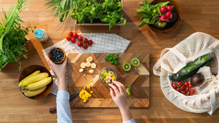 A top view of unrecognizable woman preparing fruit smoothie, sustainable lifestyle. - HPIF03080