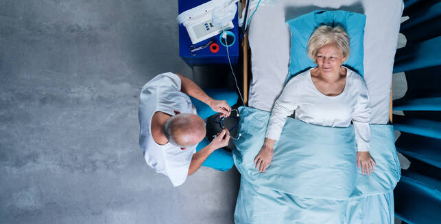 A top view of doctor with stethoscope examining patient in bed in hospital. Copy space. - HPIF03094