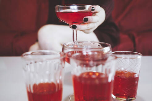 Hand einer Frau, die eine Champagnerflasche mit einem roten alkoholischen Getränk hält - SVCF00222