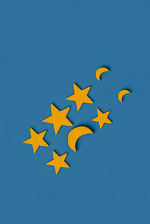 Dreidimensionales Rendering von Reihen gelber Sterne und Mondsicheln, flach auf blauem Hintergrund - GCAF00224