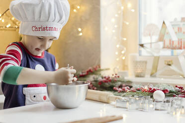 Boy preparing gingerbread dough in kitchen at home - ONAF00286