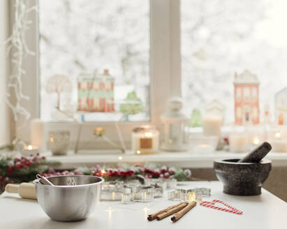 Bowl and cookie cutters by cinnamon on table at home - ONAF00288