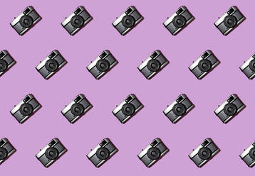 Three dimensional pattern of rows of cameras against pink background - GIOF15696