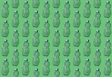 Pattern of rows of empty plastic bottles flat laid against green background - GIOF15701