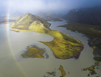 Von oben atemberaubende Drohne Blick auf grüne Berge und ruhigen See in vulkanischen Gelände gegen bewölkten blauen Himmel in Island gelegen - ADSF41603