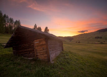 Kleines altes Haus in der Nähe von Weg und Seiser Alm unter majestätischen rosa Sonnenuntergang am Abend in Italien gelegen - ADSF41796